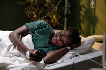 Hospitalized patient with oxygen tube, joyful, using a phone.