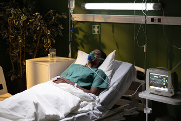Hospital scene, African woman in bed, using oxygen mask closing eyes resting recoverying.