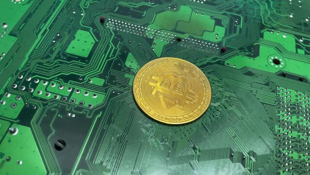 Gold bitcoin coin on a green motherboard textolite with electrically conductive circuits, concept of cryptocurrency. Bitcoin cryptomonets mining, the concept cryptography, halving. Proof of work