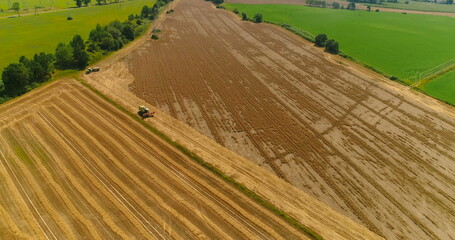 Combine harvester and tractor working in agricultural field 4K