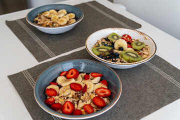 an image of various bowls of acai ice cream topped with a selection of healthy fresh fruit and oatmeal.