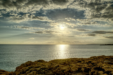 Splendid summer sunset with cloudy sky at rocky Cypriot coast