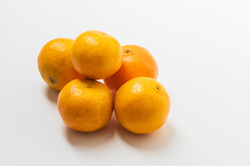 Small tangerines on a white background. Fruit for sale.