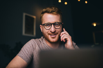 Portrait of successful Caucasian copywriter in optical eyewear looking at camera while making cell...