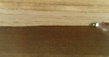 Obraz premium Aerial view of tractor plowing field.