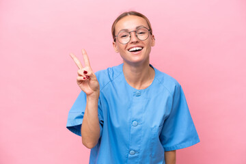 Young nurse doctor woman isolated on pink background smiling and showing victory sign