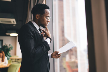 Focused black businessman reading papers