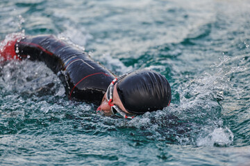 A professional triathlete trains with unwavering dedication for an upcoming competition at a lake,...