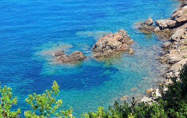 Fototapeta na wymiar crystal clear sea water on the rocky coast of the island in summer without people