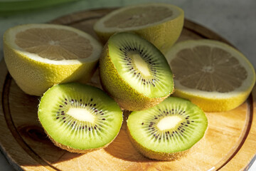 Plate with fresh cut kiwi and lemmon  on light background.