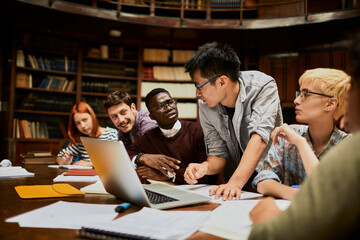 Diverse young students studying in college library