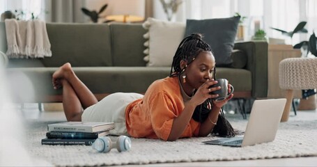 Laptop, typing and woman laying on the floor in the living room of modern apartment. Technology, elearning and young African female university student studying on a computer in the lounge at home. - Powered by Adobe