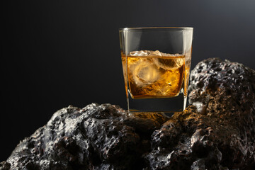 Whiskey with ice on a grey stone.