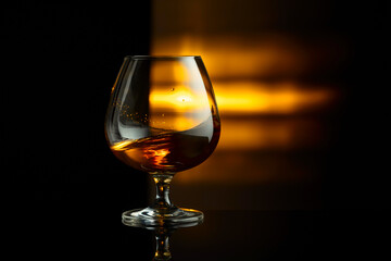Snifter of brandy on a black background.