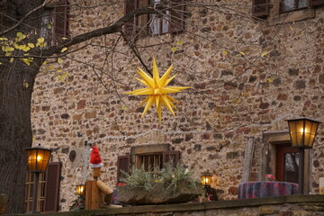 Gelber Stern vor einer alten Steinmauer in Deidesheim