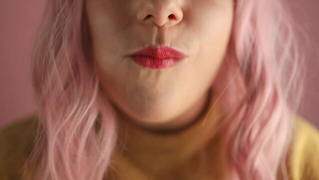 Studio portrait of happy hangry pink hair woman eat tasty sandwich with banana and looking at camera standing on pink isolated background. 
