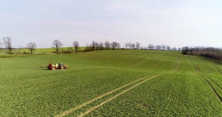Tractor spray fertilize on field with chemicals in agriculture field.
