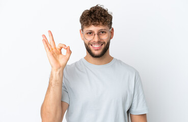 Naklejka premium Young handsome caucasian man isolated on white background With glasses and doing OK sign