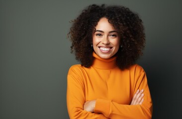Obraz premium smiling woman in orange sweater with arms crossed and smiling happy,