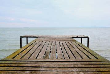 Obraz premium Wooden pier near the water against the blue sky