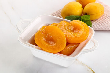 Few canned aprocots in the bowl