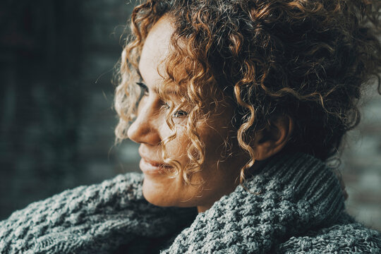 One Beauty Adult Woman At Home Alone Indoor Hugging Herself And Touching Her Neck With Smile And Serene Expression In Front Of A Light Window. People Female Living Alone. Dark Inside Portrait Of Lady