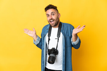 Photographer man isolated on yellow background with shocked facial expression