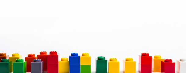 Pile of colorful lego building blocks on a white background. Educational game