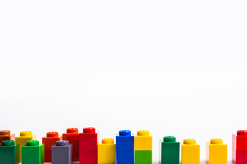 Pile of colorful lego building blocks on a white background. Educational game