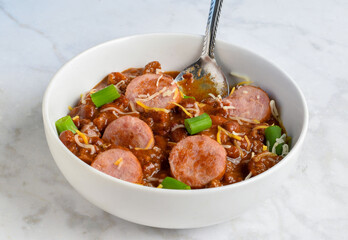 chili top with kielbasa , scallions and  cheese
