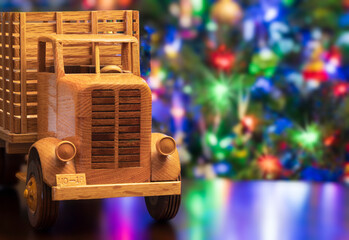 Toy wooden truck handmade in front of a Christmas tree with lights and ornaments