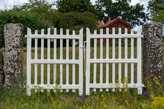 Wooden fence. Garden rustic design. Authentic old retro vintage style wooden white gate entrance gate to the garden or courtyard. Countryside cozy little house in rural area. 