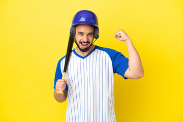 Young caucasian man playing baseball isolated on yellow background celebrating a victory