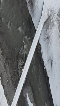 River bridge covered by snow. Aerial shoot