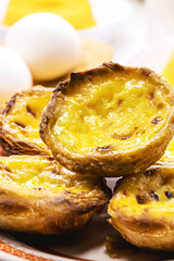 Traditional Portuguese dessert of pastel de nata, and bree de lis and bread in the background, served with coffee, typical Lisbon sweets © RHJ