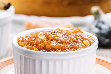 pot with homemade pumpkin jam, typical Brazilian dessert at the June and July parties, in the background fuba cake and candied sweets