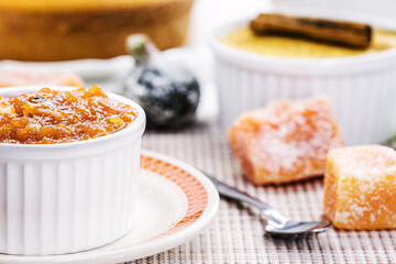 pot with homemade pumpkin jam, typical Brazilian dessert at the June and July parties, in the background fuba cake and candied sweets