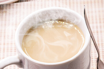 typical brazilian latte cup, or milk with coffee, drink served hot, steam and smoke coming out of the cup, for breakfast