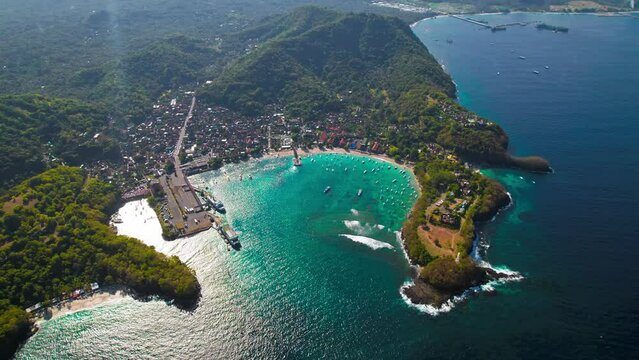 Bali Island blue lagoon beach aerial around Padangbai port marina. Drone panoramic parallax at beautiful ocean sea travel holiday resort.
