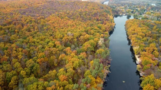 Autumn aerial forward flight above river with yellow forest on riverbanks. Cossack mountain near Koropove village on Siverskyi Donets River in Ukraine
