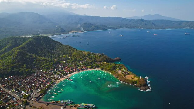 Bali Island blue lagoon beach aerial around Padangbai port marina. Drone panoramic parallax at beautiful ocean sea travel holiday resort.