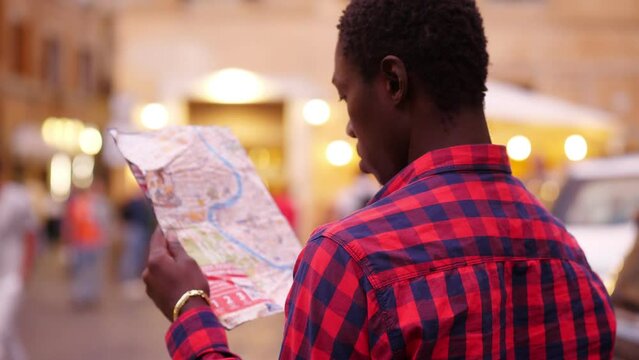 young black immigrant intent on consulting the map of the city to find a way