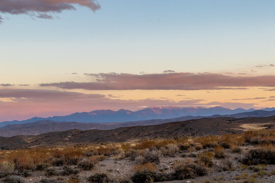 sunset in the desert, image shows the beautiful golden sunset glow in the navada desert with some clouds and a mountain view in the background, taken october 2023
