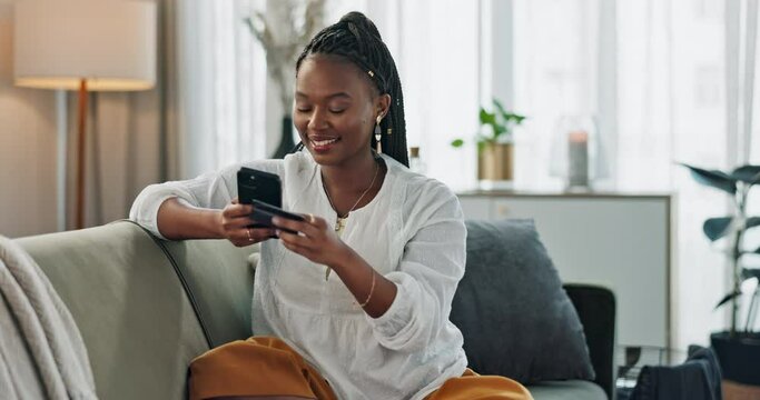 Home, credit card and black woman on a couch, smartphone and connection with payment, online shopping and smile. African person, apartment or girl on sofa, cellphone or transaction with investment