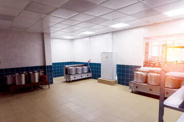 Industrial kitchen in a school restaurant with professional equipment and pans