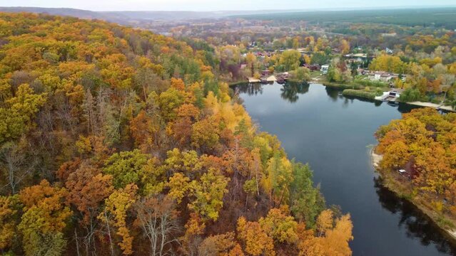 Autumn aerial drone arc flight above colorful golden forest by the river. Cossack mountain, Korobovy Hutora (Koropove village) on Siverskyi Donets River in Ukraine
