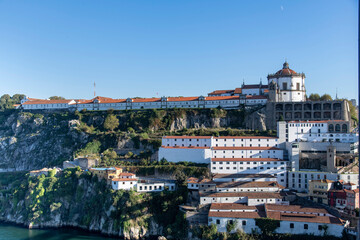 Fototapeta na wymiar Porto, Portugal, Characteristic white buildings of church and former Monastery of Serra do Pilar along banks of Douro River overlooking the Dom Luís I Bridge