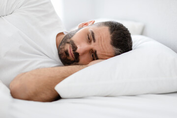 Sleepy Bearded European Man Lying In Bed Awake At Home