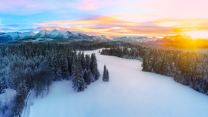 Amazing winter landscape, snow capped mountains and colorful sunset. Aerial view of winter mountain...