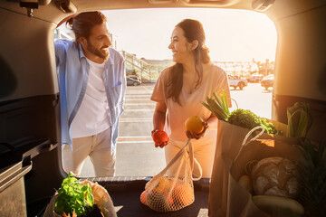 Middle eastern couple inspecting fresh produce by car